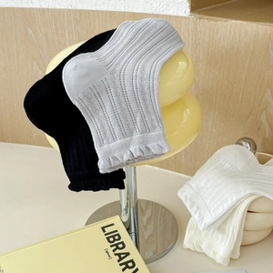 Gros plan de chaussettes en tricot côtelé avec bordure dentelle noir, blanc et gris