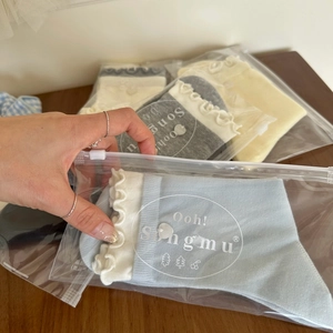 Détail de chaussettes à bord volanté dans des sacs d'emballage transparents à fermeture