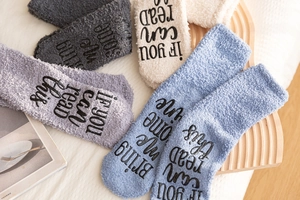 Close-up of non-slip grip lettering on fluffy coral fleece cake socks with wine slogan