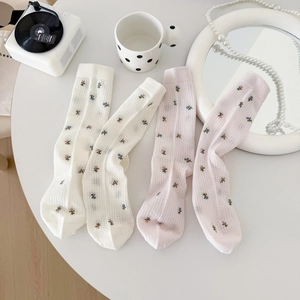 Détail de chaussettes à fleurs en maille avec texture ajourée et poignets élastiques