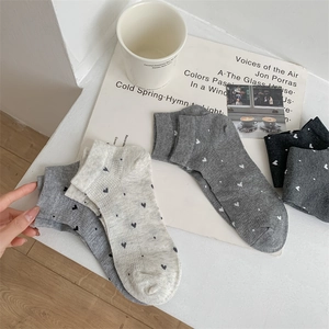 Detalle de calcetines de algodón con patrón de corazones grises y puños elásticos