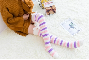 Détail de chaussettes hautes en polaire corail à rayures roses et oreilles d'alpaga