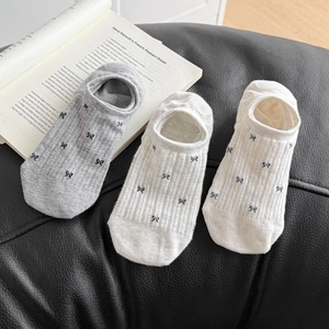 Detalle de calcetines invisibles de malla con lazos en gris claro y blanco hueso
