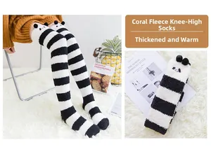 Détail de chaussettes hautes en polaire corail avec motifs panda et pompons