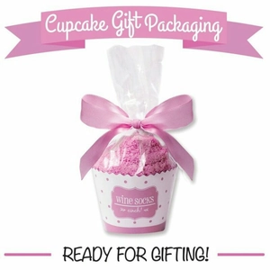 Pink cupcake-shaped fluffy coral fleece socks in a gift bag with a pink satin bow