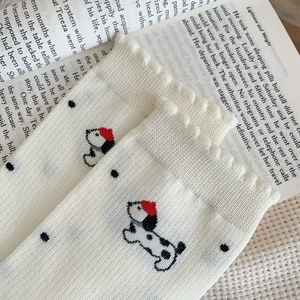 Detail of cream knit crew socks featuring cute cartoon dog embroidery and mesh dot pattern
