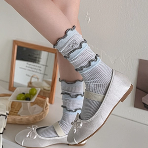 Light blue knit socks with lace trim and bow detail paired with silver ballet flats