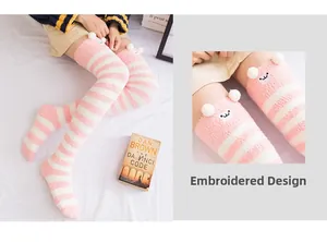 Détail de chaussettes hautes rayées roses en polaire avec broderie animale mignonne