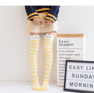Détail de chaussettes hautes rayées jaunes en polaire corail avec broderie oreilles de chat