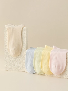 Detail of macaron pastel low cut socks featuring ribbed texture on stone props
