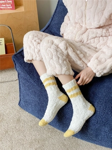 Close-up of cozy coral fleece crew socks in cream and yellow stripes on a model
