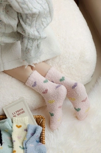 Close-up of cozy coral fleece socks with colorful heart patterns and thick warm texture