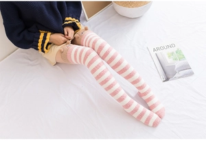 Gros plan de chaussettes hautes en polaire corail à rayures roses avec oreilles d'animaux