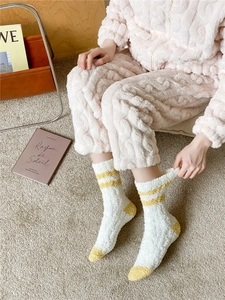 Detailed texture of thick coral fleece socks with yellow stripes and warm plush fabric