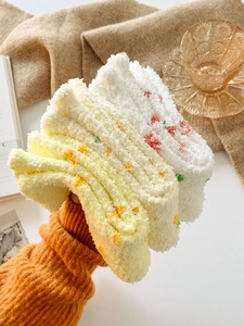 Detailed texture of thick coral fleece socks with cute floral patterns for winter