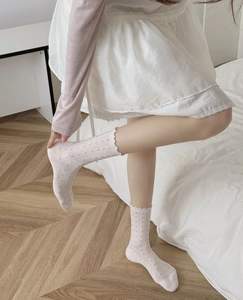 Details von rosa Pointelle-Socken mit Rüschensaum und Blumenmuster-Stricktextur