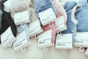 Detailed view of plush coral fleece home socks in various colors with size 37-40 tags