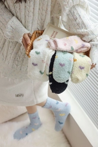 Close-up of fluffy heart-patterned coral fleece socks in pastel colors for winter warmth