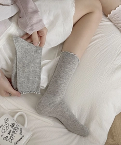 Nahaufnahme grauer Baumwollsocken mit Blumenmuster, Mesh-Gewebe und Rüschenrand
