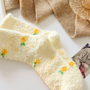 Detailed texture of thick coral fleece socks with yellow floral plush patterns