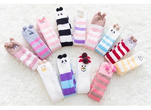 Détail de chaussettes douces en polaire corail avec motifs d'animaux sur tapis peluche