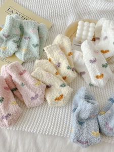 Flat lay of colorful heart pattern coral fleece socks on a cozy waffle blanket