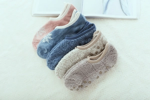 Close-up of thick coral fleece floor socks with non-slip silicone grips and snowflake patterns