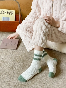 Close-up of soft coral fleece socks in white and green stripes for winter warmth