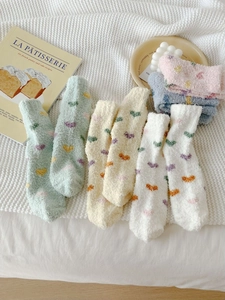 Detail of five pairs of thick coral fleece heart pattern socks in soft pastel colors