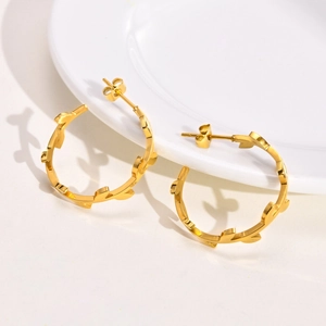 Boucles d'oreilles créoles dorées en acier inoxydable motif feuilles sur plateau