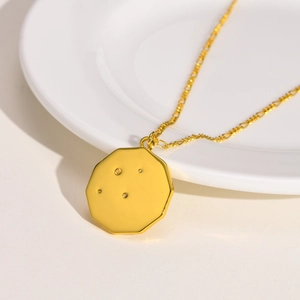 Vue détaillée du pendentif octogonal doré avec zircons posé sur une assiette blanche