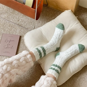 Close-up of thick coral fleece socks in beige and green for warm winter home wear
