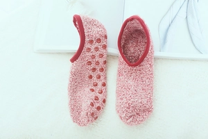 Detailed view of pink coral fleece socks with red anti-slip silicone dots on the sole