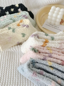 Detail of soft heart pattern coral fleece socks displayed in a cozy home setting