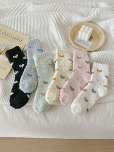 Close-up of six pairs of thick coral fleece socks with colorful heart patterns