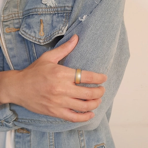 Man wearing a two-tone brushed gold and polished silver tungsten ring on his hand