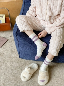 Detailed texture of thick coral fleece socks paired with plush slippers for winter warmth