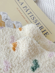Close-up of thick coral fleece socks with colorful 3D heart patterns and soft texture