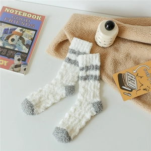 Detailed shot of plush coral fleece socks featuring warm thermal texture and gray stripes