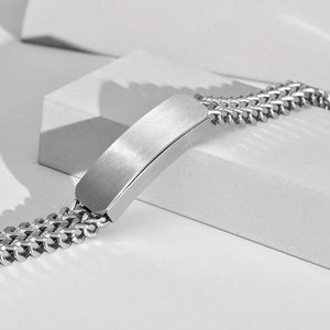 Close-up of double-layered stainless steel chain bracelet with a polished metal plate