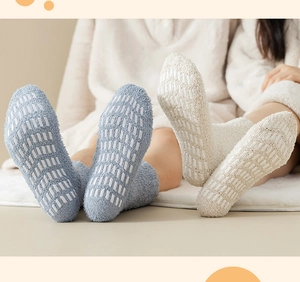 Detail of non-slip silicone grips on warm coral fleece floor socks in blue and beige