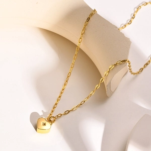 Gros plan détaillé du pendentif cœur doré avec gravure étoile et incrustation zircon