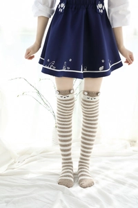 Détail des chaussettes hautes rayées en polaire corail avec décorations oreilles d'animaux 3D