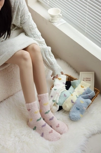 Close-up of fluffy coral fleece socks with colorful heart patterns for winter warmth