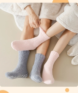 Close-up of thick coral fleece socks with anti-slip silicone dots on soles for home