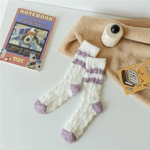 Detail view of warm cream coral fleece socks with purple accents on heel and toe