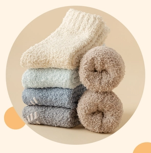 Close-up of thick coral fleece socks showing non-slip rubber grips on a soft texture