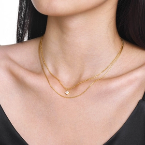 Primo piano della collana a due strati dorata con pendente in zircone quadrato