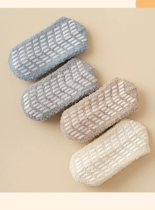 Detailed view of four colorful coral fleece floor socks with non-slip silicone grippers