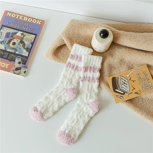 Detail of soft coral fleece socks with pink stripes on white plush home sleepwear